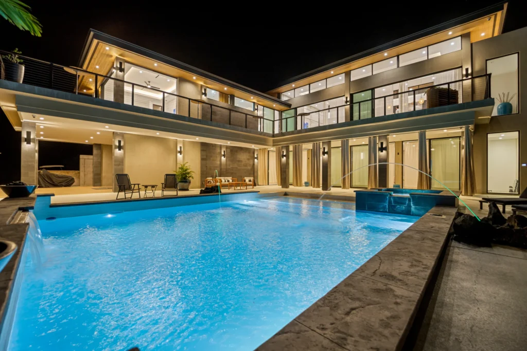 Luxury modern home photographed at twilight with a lit swimming pool